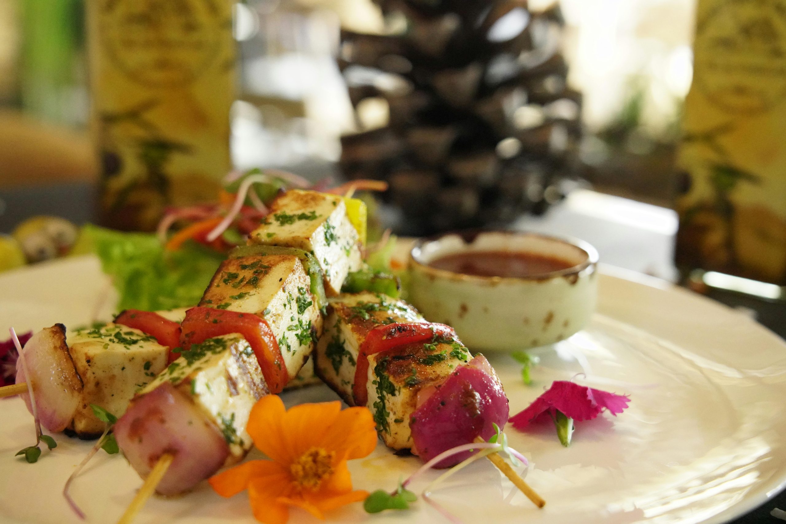 A delicious plate of grilled Cap Nach pork skewers served with fresh herbs and a dipping sauce at a local restaurant in Sapa.