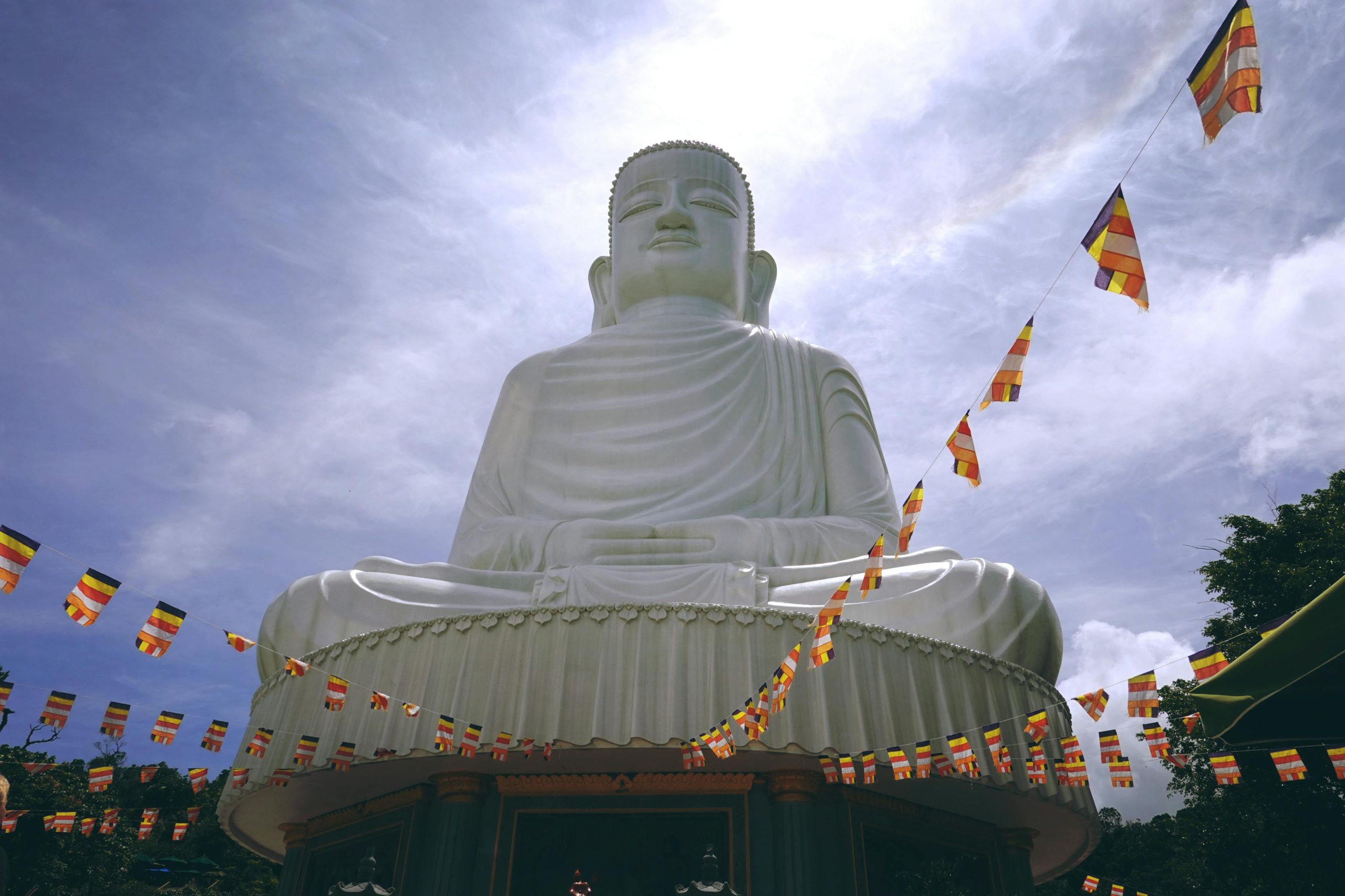 A majestic 67-meter-tall white Lady Buddha statue at Linh Ung Pagoda, Son Tra Peninsula, overlooking the turquoise ocean and Da Nang coastline under a clear blue sky
