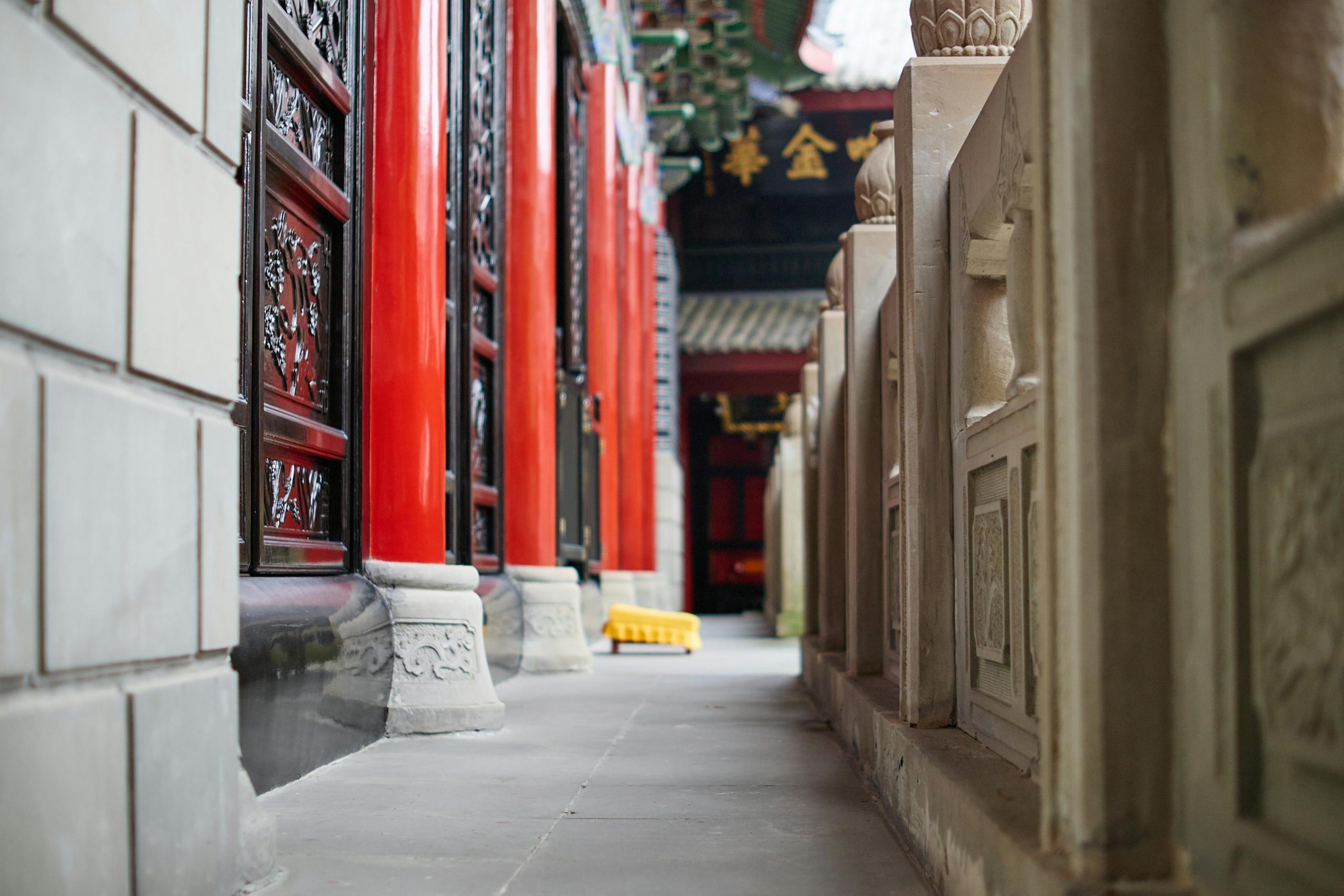 Detailed interior of King Dinh Tien Hoang Temple in Hoa Lu, showing intricate wooden carvings, red lacquered pillars, and a golden altar